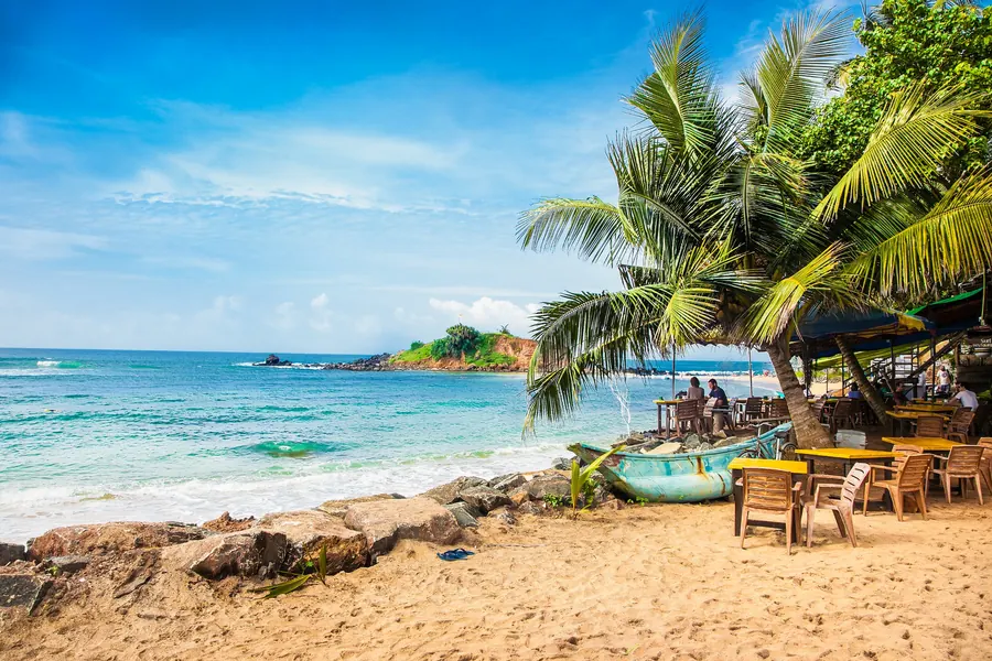 Turquoise sea, palm trees and a beach cafe on the Sri Lankan coast